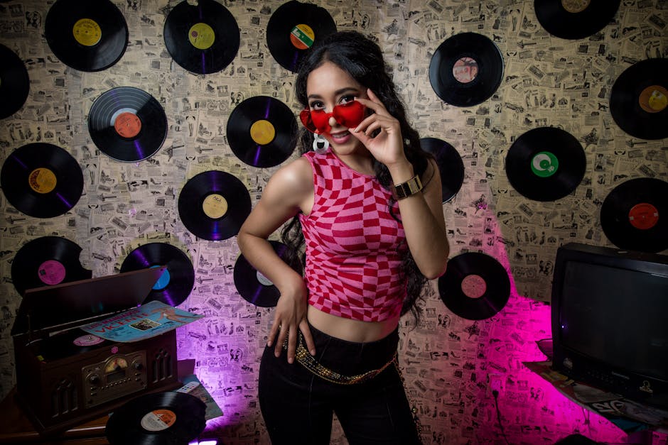 Woman in a Pink Tank Top Posing next to a Record Player